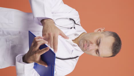 Vertical-video-of-The-doctor-examining-the-paperwork-is-thoughtful.